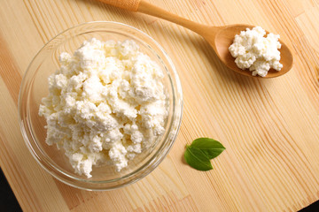 cottage cheese in a glass bowl on a wooden background