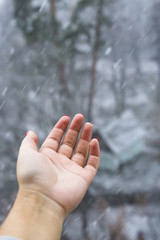 A woman's hand reaches for the snow. Winter concept