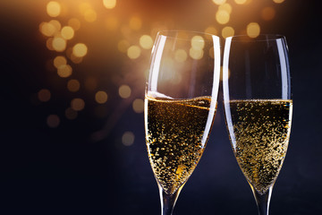 two champagne glasses ready to bring in the New Year - holiday lights and fireworks in the background © Melinda Nagy