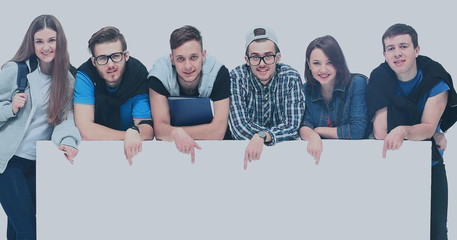 Full length portrait of confident college students displaying blank billboard against white background