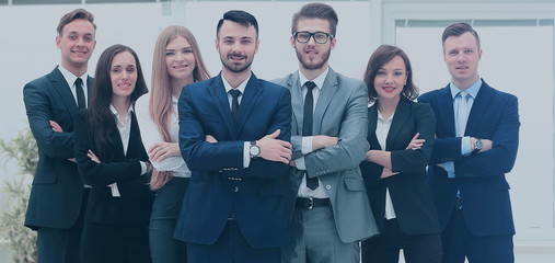 Smiling and confident business team standing in front of a bright window