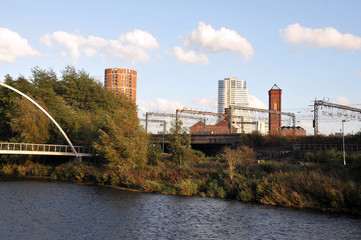 the river aire in leeds taken from the footpath showing the footbridge south back and holbeck with the railway tracks in between