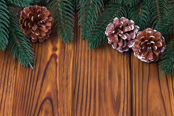 Christmas decoration cones fir on brown wooden background.