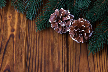 Christmas decoration cones fir on brown wooden background.