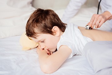 Obraz na płótnie Canvas Doctor examines child with stethoscope