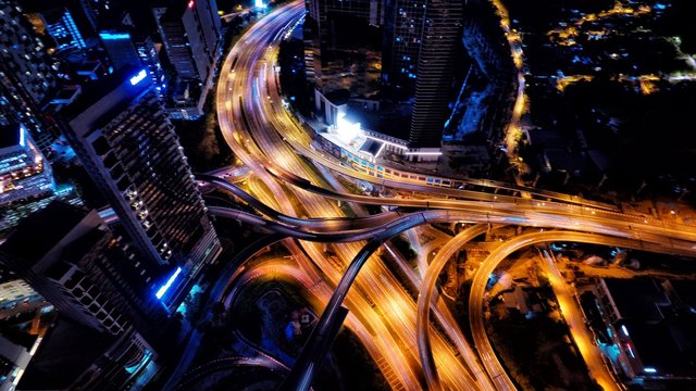 Aerial photography of urban city highway with traffic's light trail at night.