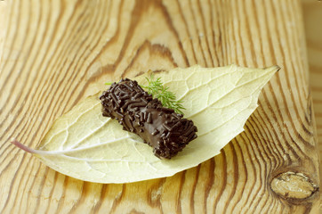 chocolate candy on autumn leaf, on a wooden counter
