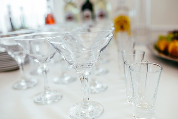Different alcohol drinks in goblets and wine glasses on wedding buffet table