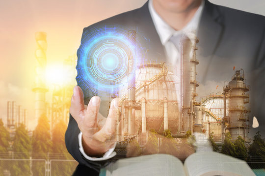 Double exposure of businessman hand hold blue circular circuit hi-tech, oil fuel, Electric generating factory, plant and sunset as business, control, technology, future, industrial and energy concept.