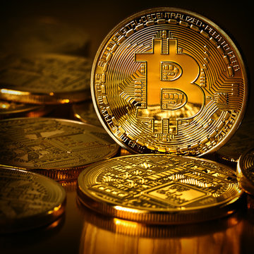 Golden Bitcoins on a gold background .Photo (new virtual money ) New crypto currency in the form of the coins. 