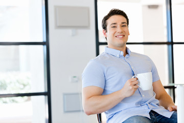Young businessman in office with a mug
