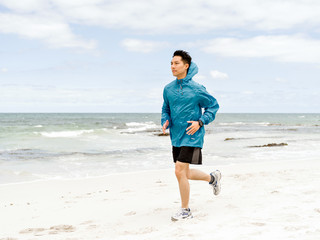 Young man running along seaside