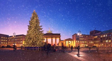 Fototapeten Brandenburg Gate in Berlin with Christmas tree and falling snow in the evening © tilialucida