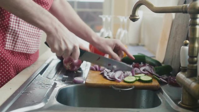 Man cuts red onion in timelapse