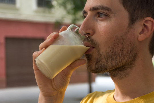 Jeune homme buvant un lait v&eacute;g&eacute;tal