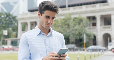 Hispanic man use of mobile phone in city