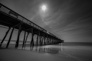 Black and white photo of Myrtle Beach pier during a full moon