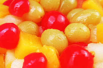 Fruit salad texture. Fruits as background pattern. Exotic Fruits Fruit salad with cocktail cherry sour cherry mango pineapple grapes,pear,maracuja,papaya in syrup. Food.