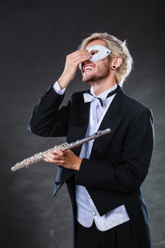 man in carnival mask playing flute