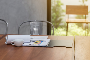 Coffee cup with chart and report on work table in the morning,Selective focus