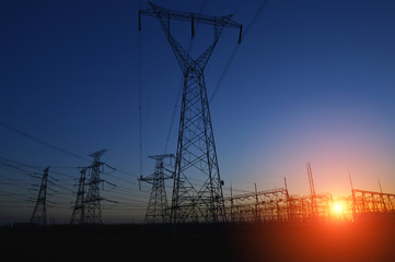 Fototapeta premium The silhouette of the evening electricity transmission pylon