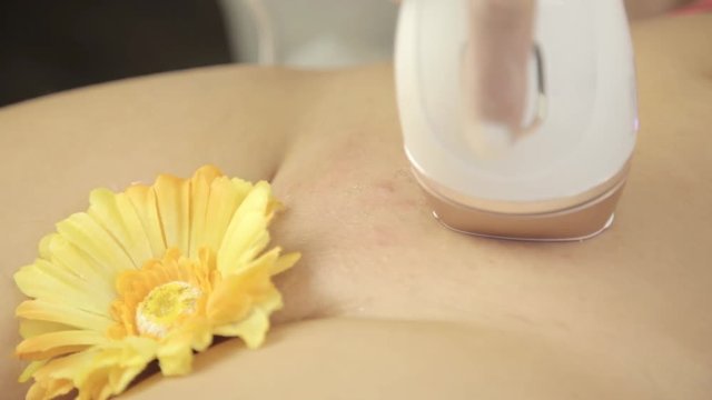 client receives epilation of bikini zone in beauty salon with electronic devices