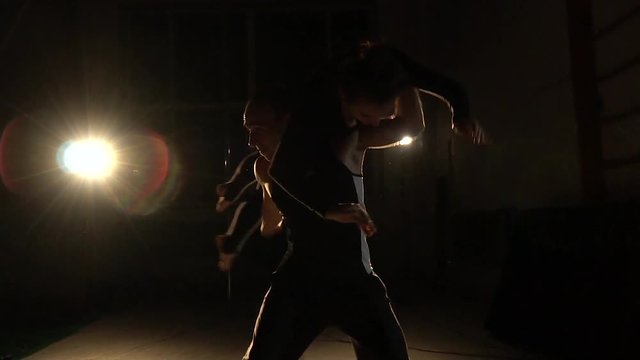 A pair of circus gymnasts, a man raises a woman, rollback camera. Slow motion