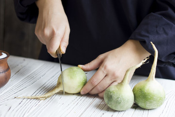 hands cook cut radish with a knife