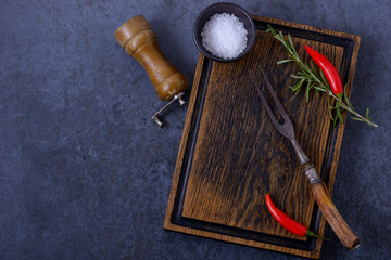 Empty wooden board and chili pepper, rosemary, salt