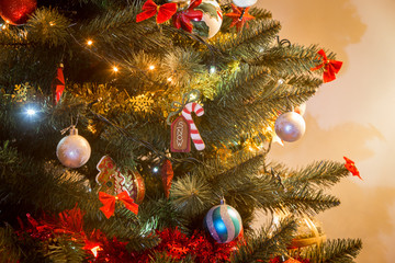 Various Christmas decorations on a tree in a home.