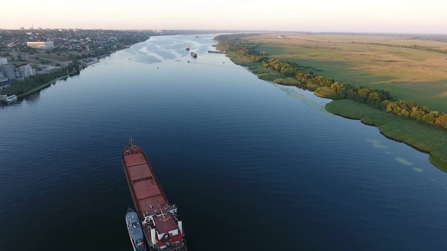 An amazing bird`s eye view of the Dnipro with a floating long barge and splendid green riverbanks. The skyscape looks dreamlike   