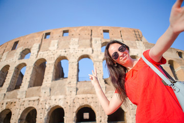 Young woman taking selfie portrait in front of Colosseum in Rome, Italy. Happy girl on vacation