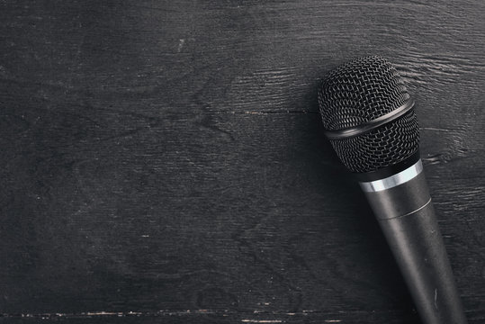 Microphone on a wooden black table. Studio. Top view. Free space for text. Copy space.