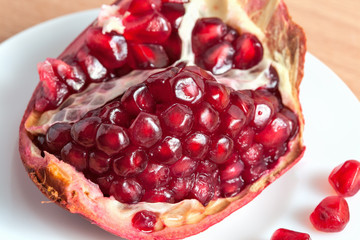 The cut pomegranate and grains on a plate.