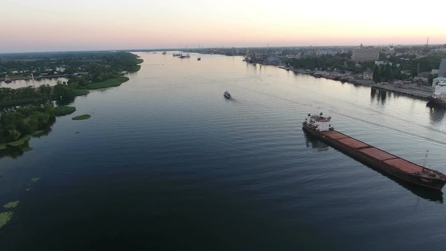 A wonderful bird`s eye view of the wide Dnipro with green riverbanks and floating ships far away at a splendid sunset. The skyscape is fine.