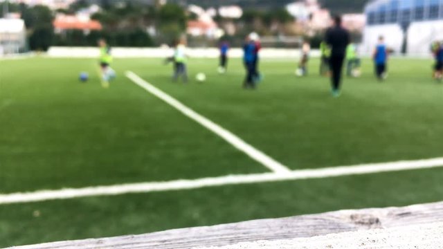 Kids on football training outdoor on green field blurred