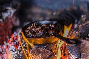 Roast chestnuts on the fire in a cast-iron frying pan.