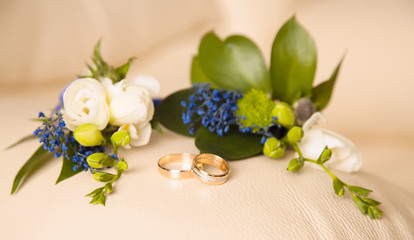 Wedding bouquet of flowers and rings of newlyweds.