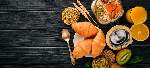Healthy Diet Breakfast. Nuts, oat flakes, fruits, croissants, on a wooden surface. Top view. Free space for text.
