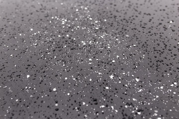 Snowflakes on a black car as a background