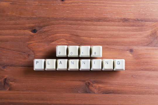 Planning 2018 new year on computer keyboard keys buttons on wooden background