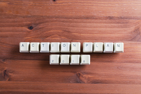 Action plan 2018 on computer keyboard keys buttons on wooden background