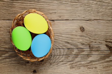 Easter eggs in basket on wooden background