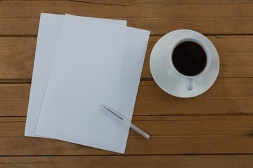 Obraz na płótnie Canvas Black coffee and blank paper on wooden plank
