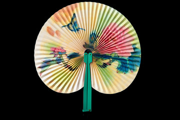 Closeup of Traditional Chinese fan on black background.