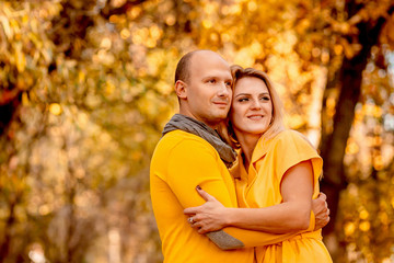 The husband embracing his wife and standing in the forest