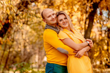 Fototapeta premium The husband embracing his wife and standing in the forest