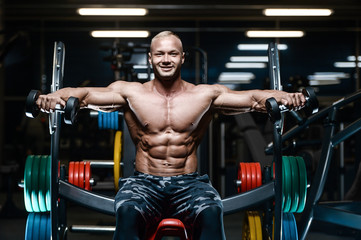 Naklejka premium Brutal strong bodybuilder athletic men pumping up muscles with dumbbells.