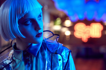 Futuristic neon lighted close up portrait of a sexy woman with white bob hairstyle wearing silky...