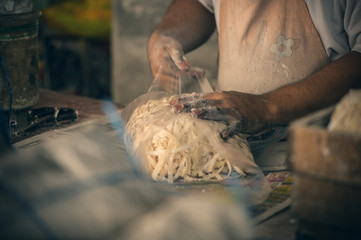 A man packs handmade noodles on the local market in Chinatown, Kuala lumpur. Street food  in Kuala lumpur, Malaysia